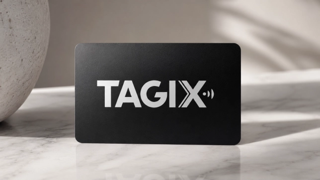 Carte NFC TAGIX noire avec logo blanc, présentée sur une surface en marbre dans un décor moderne et minimaliste.