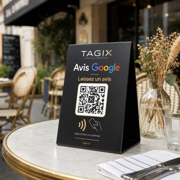 Chevalet TAGIX pour avis Google avec QR code et NFC, posé sur une table de terrasse de café.